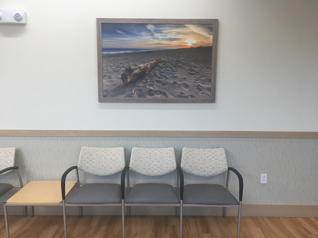 Fine art seascape print by Mike Dooley displayed above a chairs in a medical office waiting room, evoking calm and confidence.