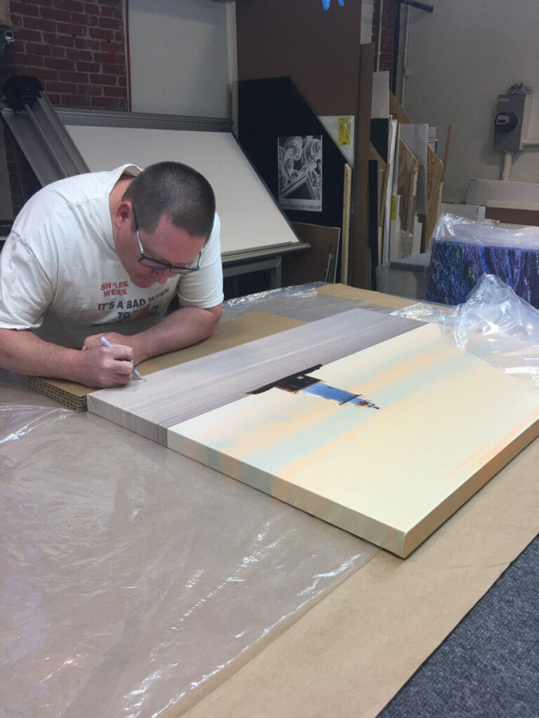 Fine Art Landscape Photographer Mike Dooley signs a print of Sakonnet Lighthouse of the coast of Rhode Island