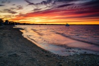 A breathtaking summer sunset over Conimicut, painting the sky with vibrant hues above tranquil waters.
