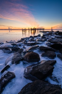 Ice wraps the rocks along the shoreline at Rocky Point Park in Warwick, Rhode Island