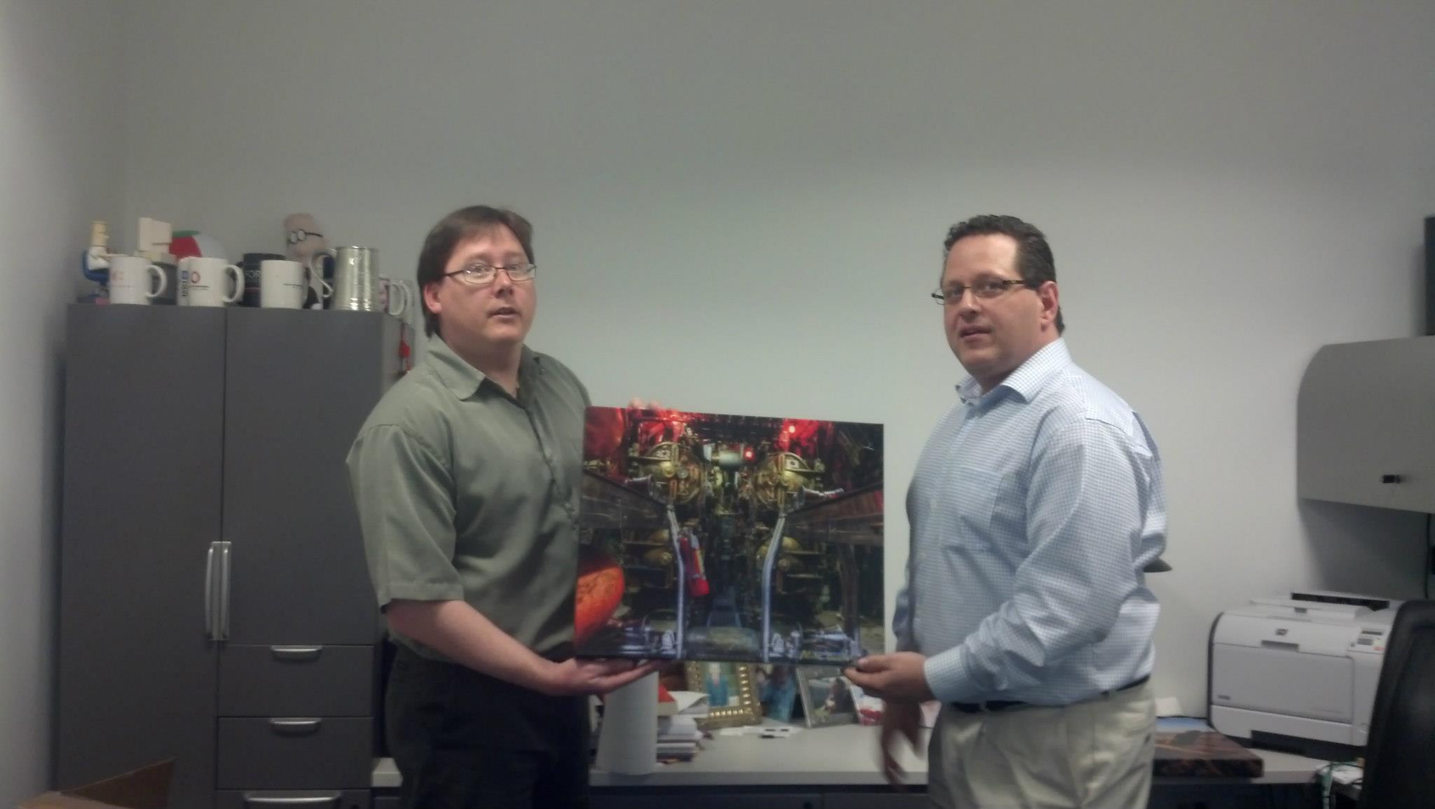 Gallery Wrap - Rhode Island Photographer Mike Dooley holds one of his images printed as a large gallery wrap. The image being held is of a torpedo room aboard the WWII submarine the USS Lionfish