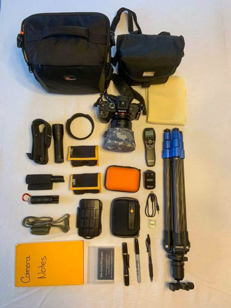 Flat-lay photo of Mike Dooley’s camera gear, lenses, and tools for fine art landscape and seascape photography.