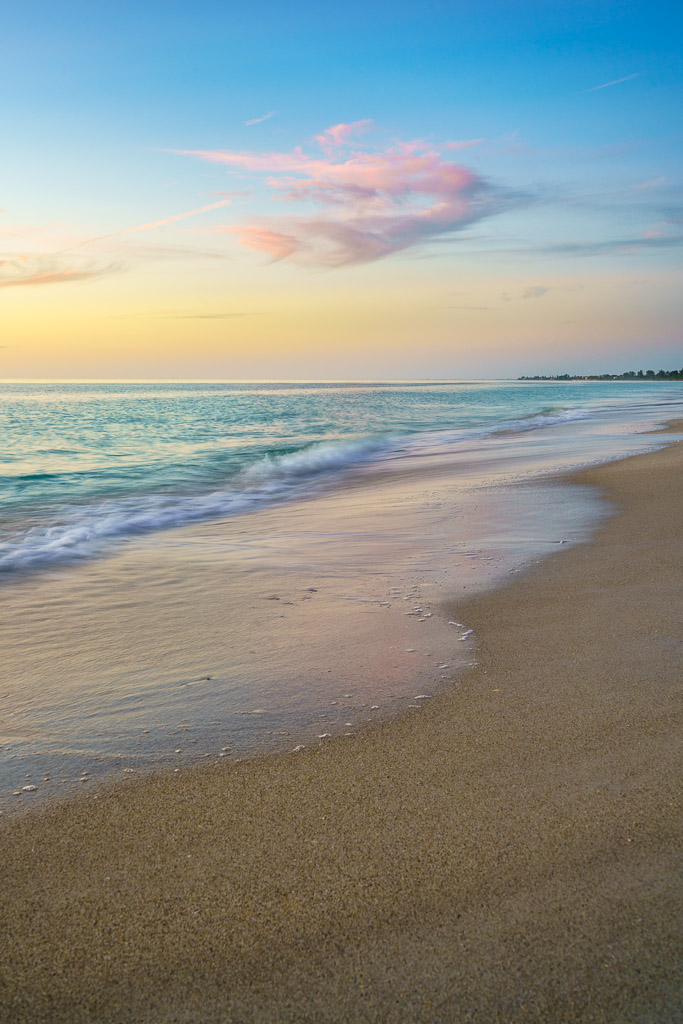 Pink skies over Nokomis Beach, Florida, with gentle waves and soft sand, perfect for vertical photography inspiration.