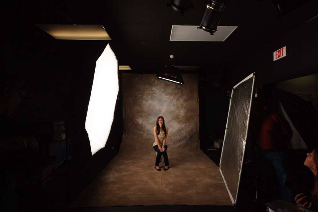 Behind-the-scenes black and white photograph of a portrait setup showing studio lights, backdrop, and photography equipment, capturing the process of fine art portrait photography by Mike Dooley.