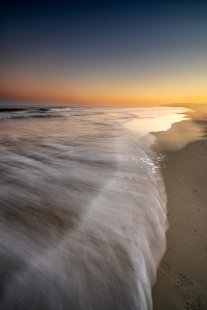 Mystical sunrise over Hunting Island, South Carolina, with soft golden and lavender light reflecting on the ocean and shoreline.