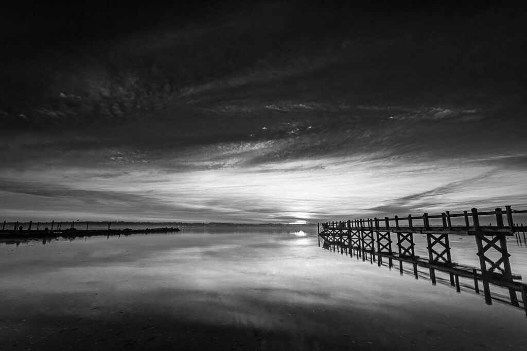 Just as dawn breaks across Narragansett Bay, a pier reaches for the sun