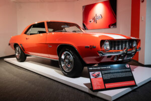 1969 Chevrolet Camaro Z28 in bold orange with white racing stripes at the Newport Car Museum, photographed as a fine art print by Mike Dooley.