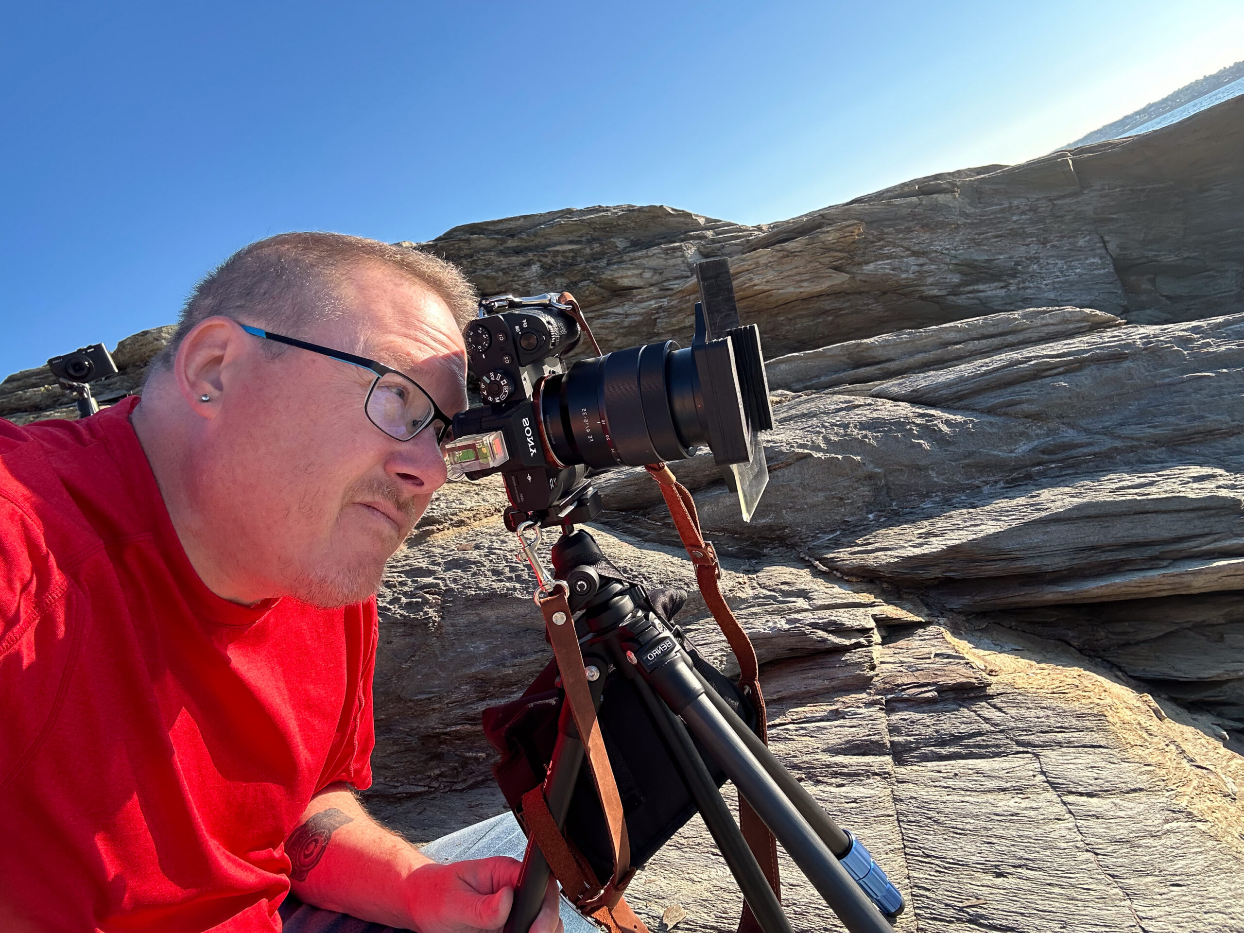 Mike Dooley photographing the rocky coastline at Beavertail State Park in Rhode Island
