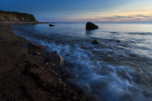 Waves crashing on Block Island rocky shore under a dramatic sky