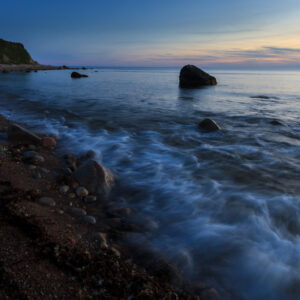 Waves crashing on Block Island rocky shore under a dramatic sky