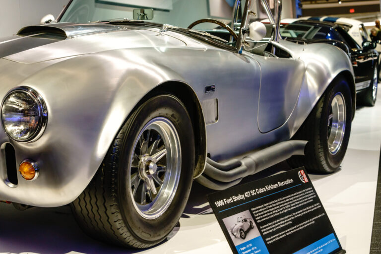 Side view of a bare aluminum Shelby Cobra at the Newport Car Museum