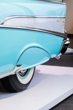 Rear quarter panel of a baby blue and white Chevy Bel Air with chrome accents at the Newport Car Museum