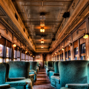 Interior of a vintage dining car train with wood paneling and classic seating, photographed as a fine art print by Mike Dooley.
