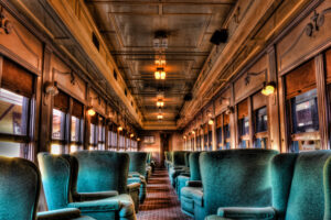 Interior of a vintage dining car train with wood paneling and classic seating, photographed as a fine art print by Mike Dooley.