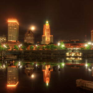 Full moon rising next to the Superman Building at night in downtown Providence, Rhode Island.