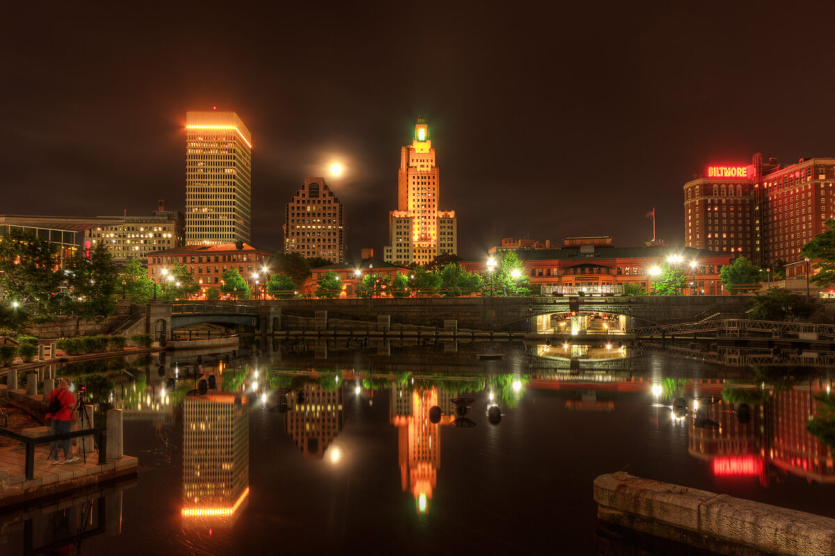 Full moon rising next to the Superman Building at night in downtown Providence, Rhode Island.