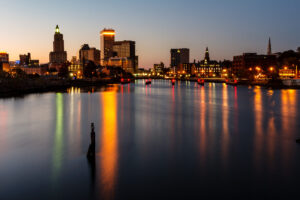 Providence skyline at twilight with city lights beginning to glow, photographed by Mike Dooley.