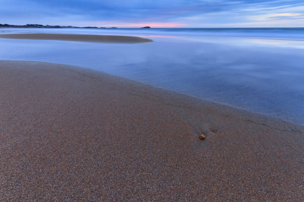 Sunrise at Narragansett Beach in Rhode Island, with soft morning light over the waves, photographed by Mike Dooley.