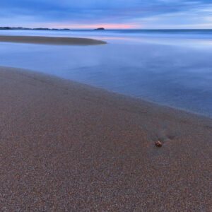 Sunrise at Narragansett Beach in Rhode Island, with soft morning light over the waves, photographed by Mike Dooley.