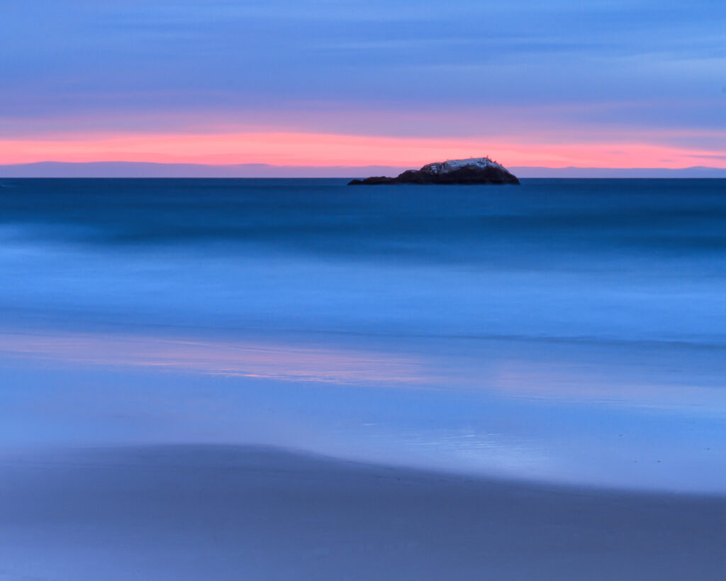 Sunrise at Narragansett Beach, Rhode Island, with Whale Rock—the remaining lighthouse foundation—photographed by Mike Dooley.
