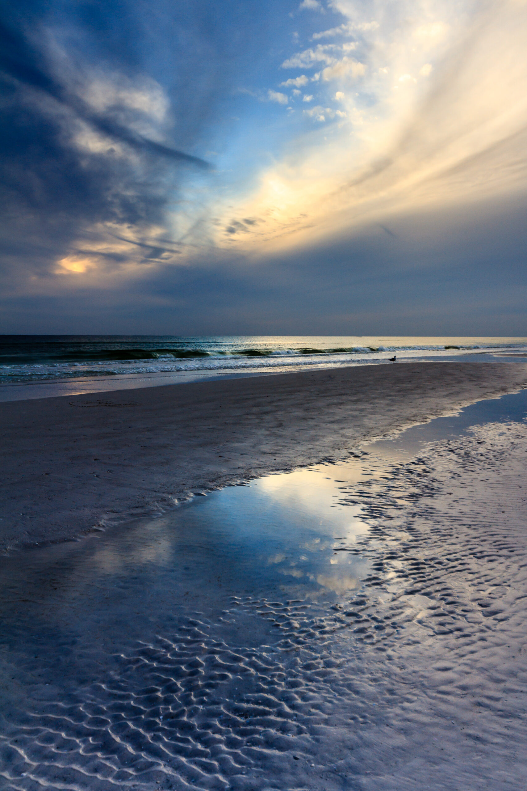 Sunset at Siesta Key Beach, Florida, with colorful sky and calm waves, photographed by Mike Dooley.