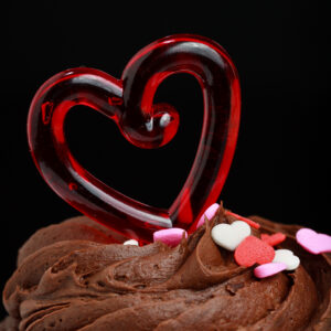 Close-up of a chocolate cupcake with a red heart on top, photographed as a fine art print by Mike Dooley.