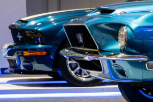 Front views of three Mustang cars from different generations at the Newport Car Museum