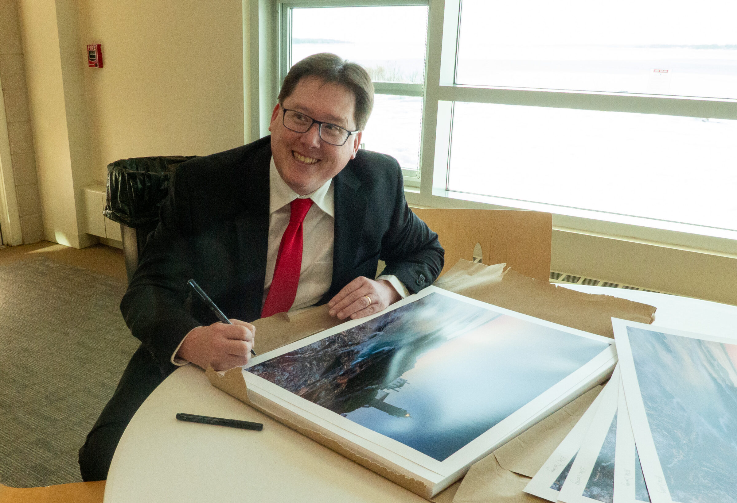 Mike Dooley, fine art photographer, signing a Seasons Pass limited edition print before framing and delivery