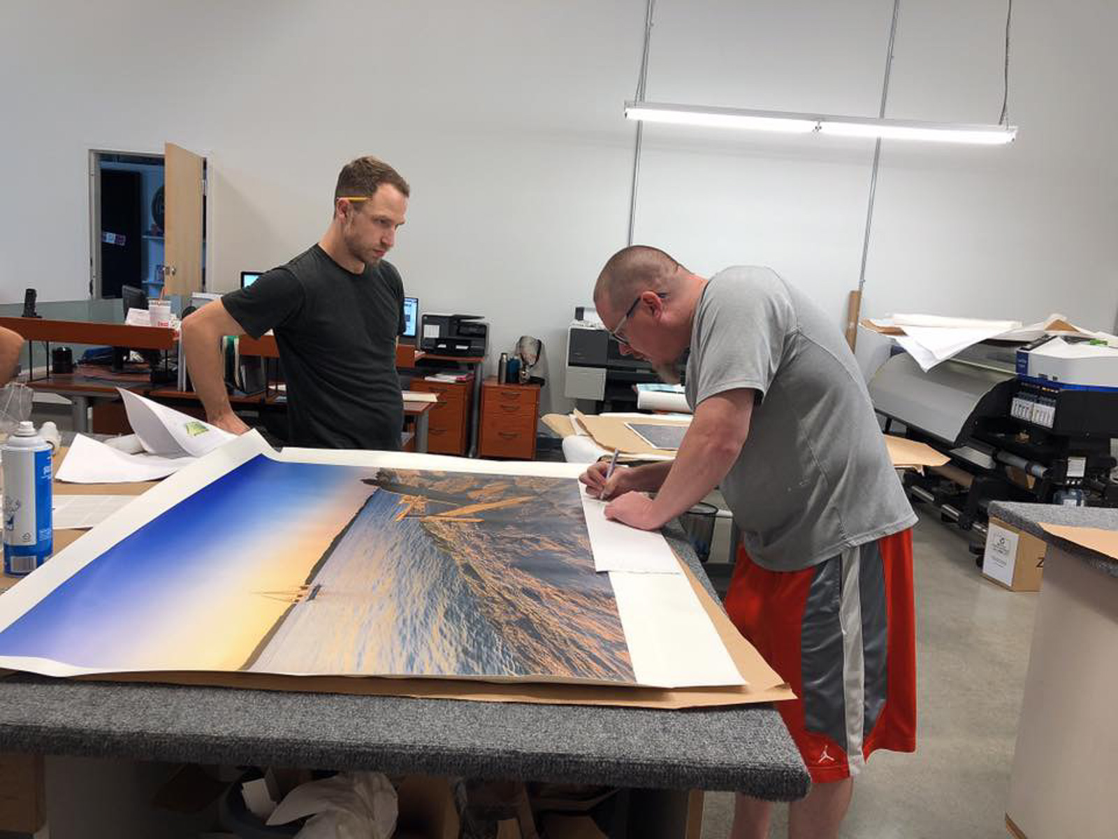 Photographer Mike Dooley signing a fine art photographic print before professional framing and delivery to a client.