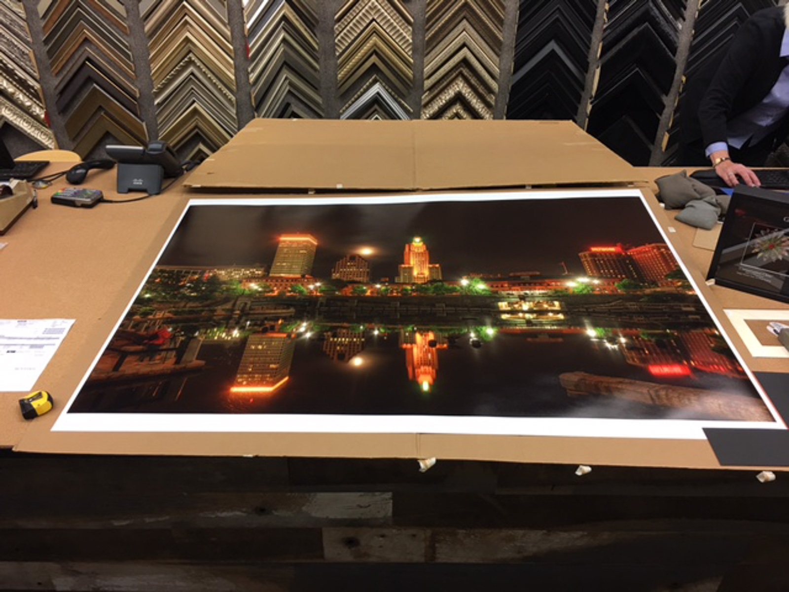 Very large paper print of Full Moon Over Providence by Mike Dooley laid out on a framing table for signing before installation in a corporate boardroom.