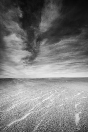 Wind-blown sand and stormy clouds over Jockey's Ridge State Park, Outer Banks, North Carolina, black and white photograph by Mike Dooley